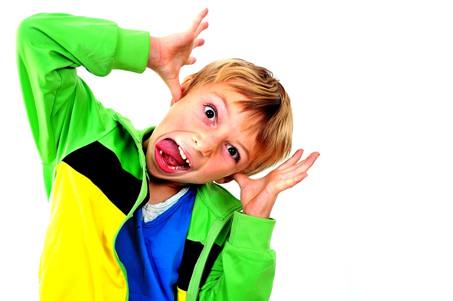 Young boy in studio in green cardigan on white background