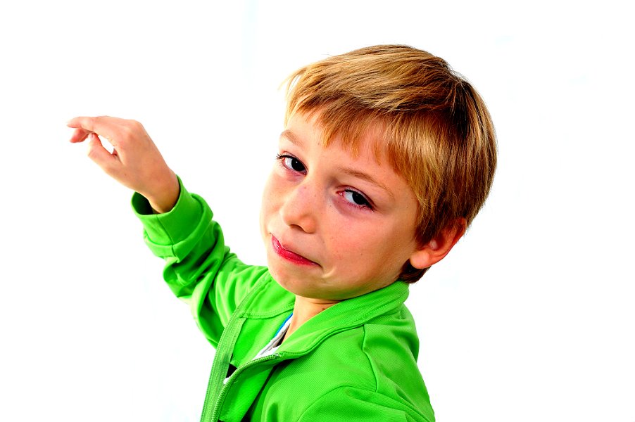 Young boy in studio in green cardigan on white background