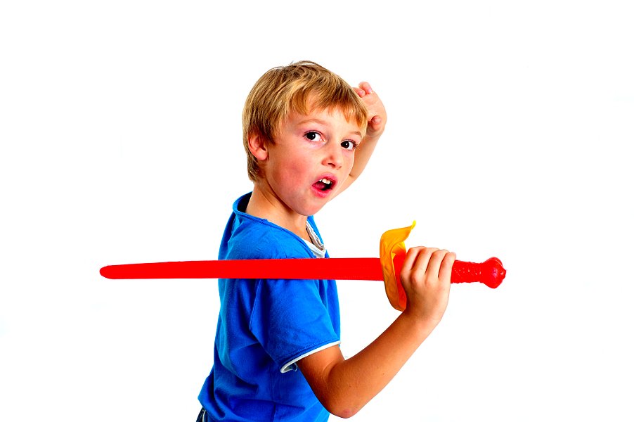 Young boy in studio playing with sword on white background